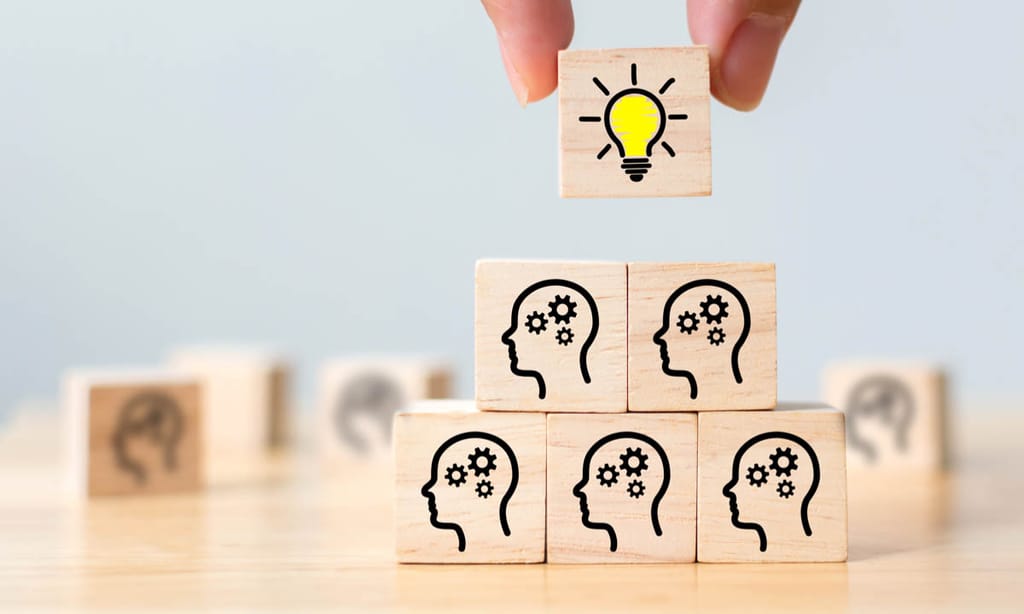 Blocks with heads on them and a bulb placed on top to signify workforce intelligence.