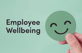 A coaster with a smiley face on it with the words employee wellbeing