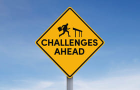 A street sign with ‘challenges ahead’ to symbolize the challenges of hybrid workforce management.