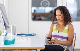 An employee of a disengaged workforce on her personal phone at work.