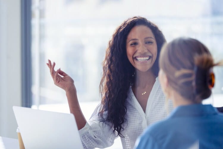 Two employees having a positive conversation about productivity, collaboration and engagement.