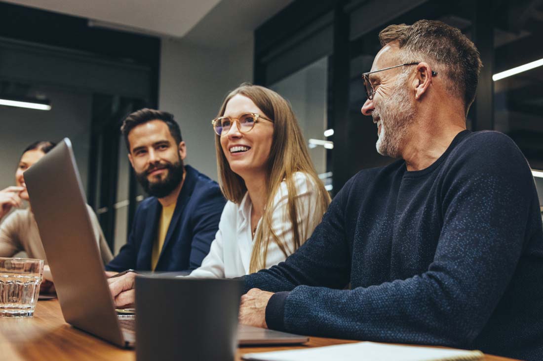 A group of coworkers discussing headcount and resource planning in an office.