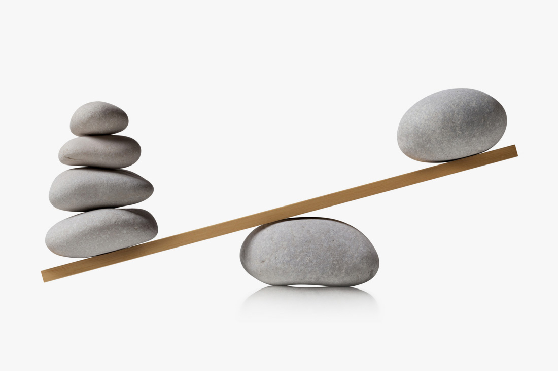 A balance with uneven weights of stones stacked to signify workload analysis.