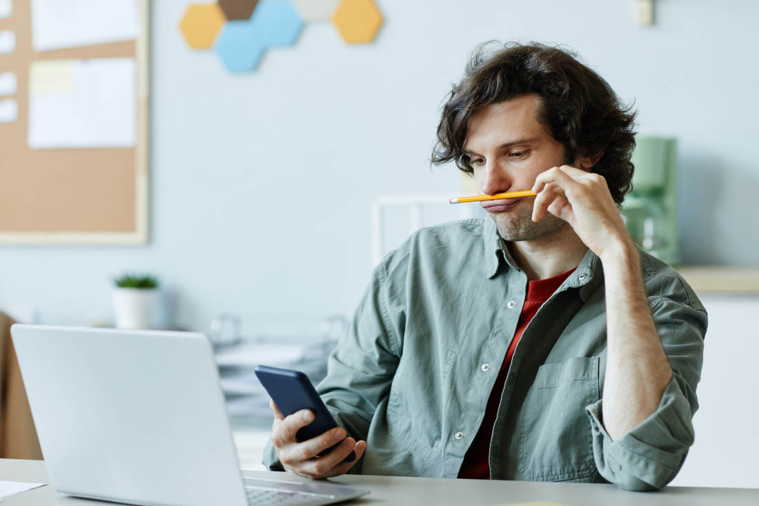 An employee interrupted by their phone to illustrate how interruptions affect productivity.